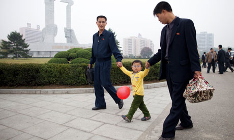 A family passes before the Party Foundation Monunment in Pyongyang. A family passes before the Party Foundation Monument. Photograph: Dan Chung/Guardian